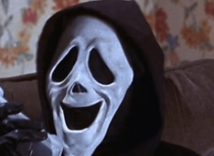 The killer holding a phone with a weird expression on his mask