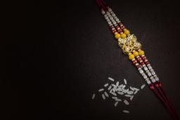 An elegant Rakhi, traditional Indian wrist band on black background 1223602  Stock Photo at Vecteezy