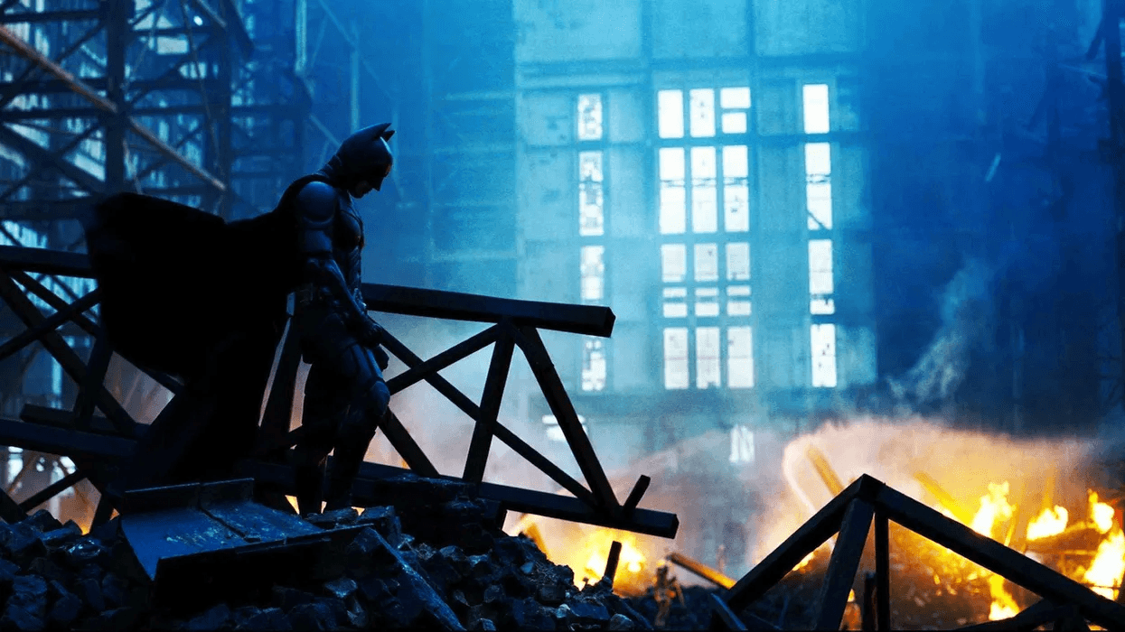 Batman looking down at a destroyed property