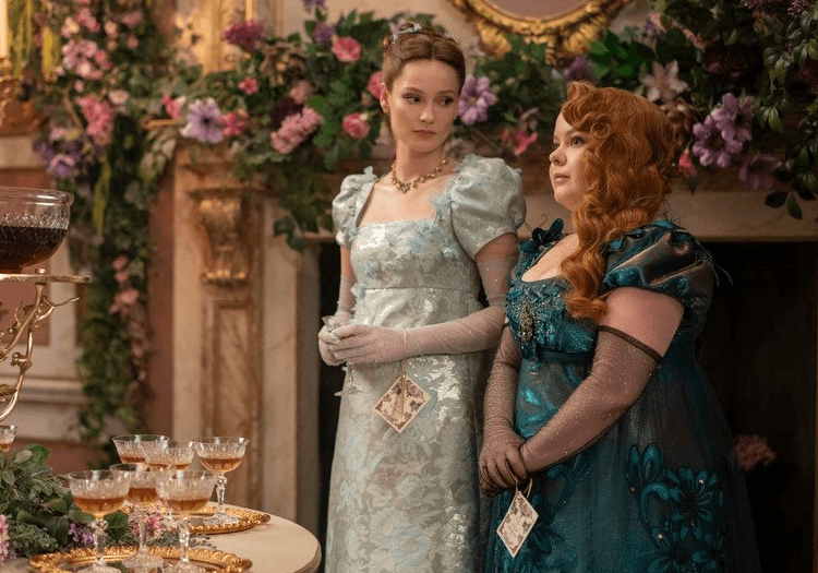 Two women standing in signature dresses in Bridgerton