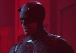 Daredevil in his black suit standing against a red background