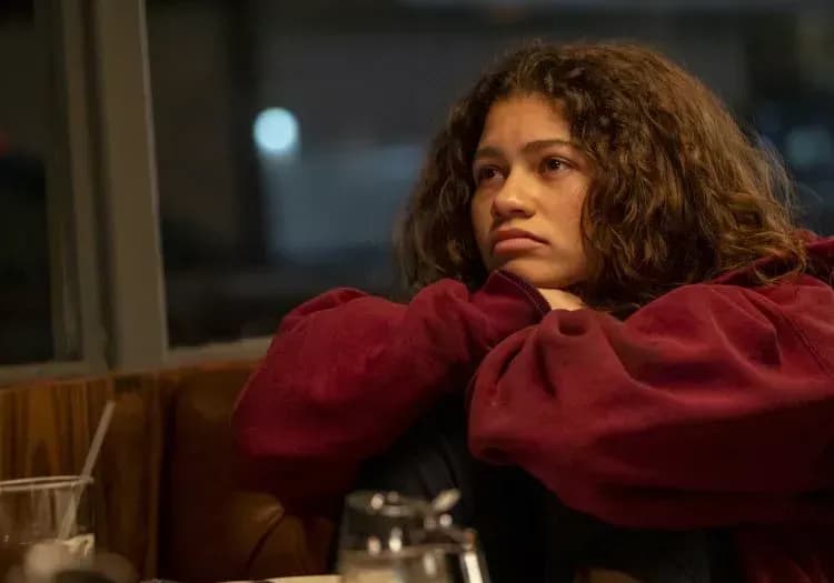 Zendaya as Rue in Euphoria sitting in a red ensemble