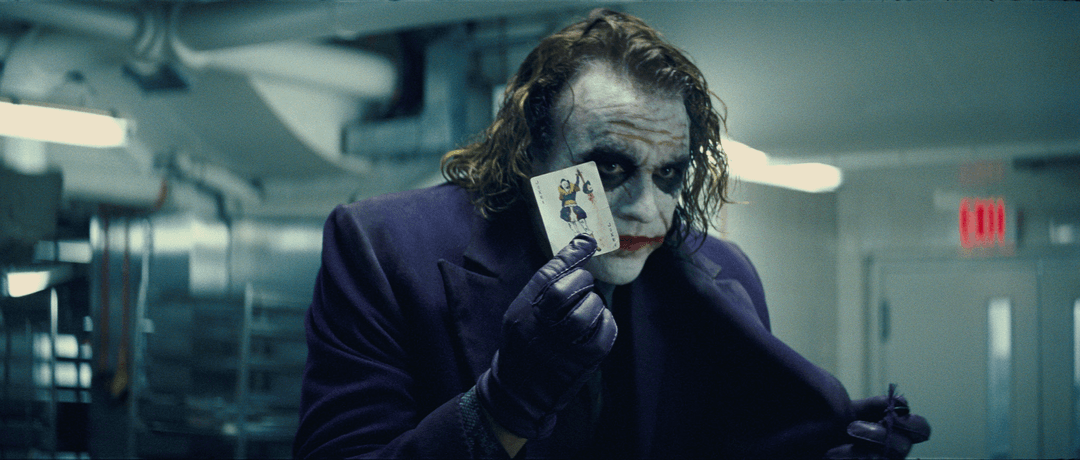 Joker holding a Joker card in The Dark Knight
