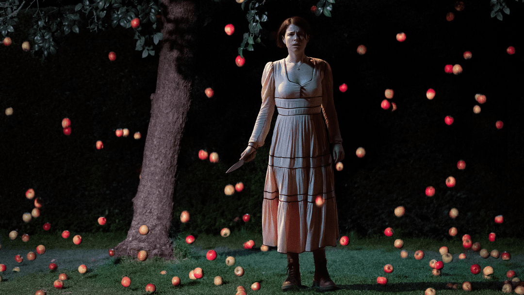 Several apples falling over a woman