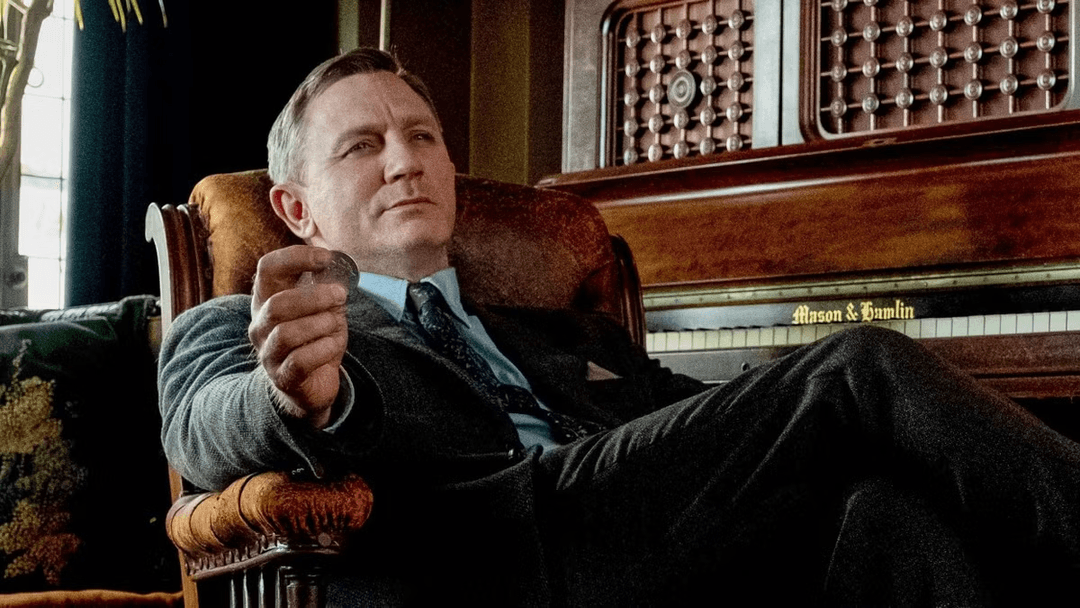 Benoit Blanc sitting near a piano