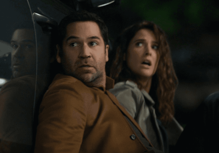 Two characters hiding behind a car in The Lincoln Lawyer