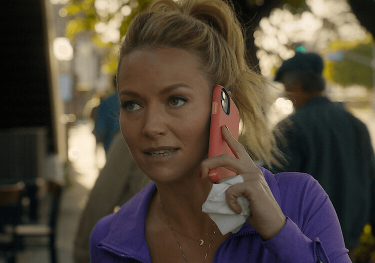 Lorna Quinn on a phone call outdoors in a purple jacket