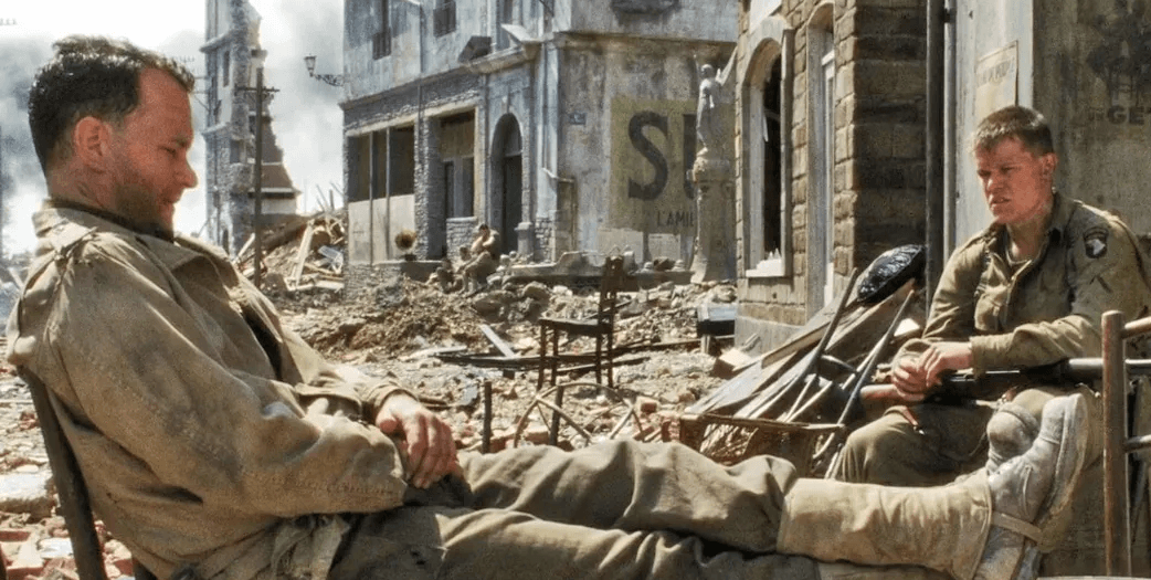 Tom Hanks and Matt Damon sitting in Saving Private Ryan