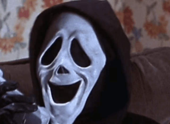 The killer holding a phone with a weird expression on his mask