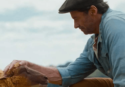 Hugh Jackman petting a sheep in The Sheep Detectives