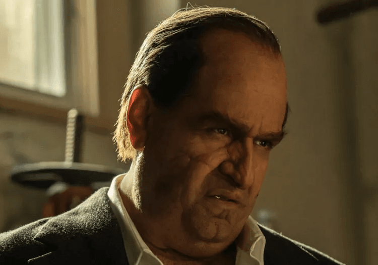 Oz Cobb standing and smirking