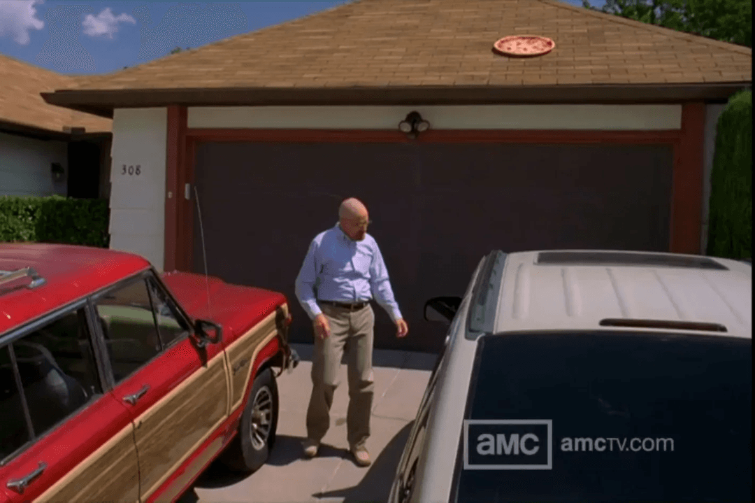 Walter White standing between two cars