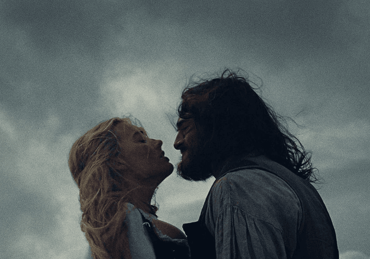 Jacob Elordi and Margot Robbie standing in Wuthering Heights