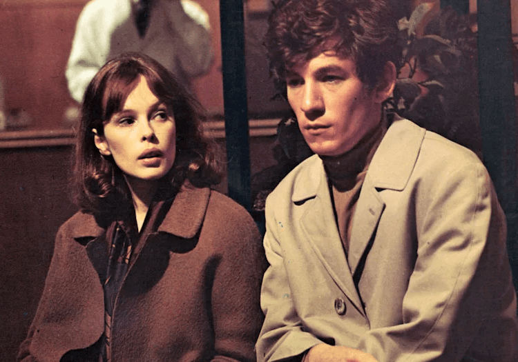Young Ian McKellen sitting with a lady